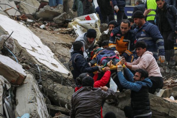 Người dân và các nhóm cứu hộ đang giải cứu một người trên cáng từ một tòa nhà bị sập ở Adana, Thổ Nhĩ Kỳ, hôm 06/02/2023. (Ảnh: Hãng thông tấn IHA qua AP)