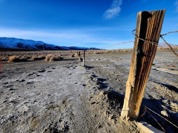 Một lòng hồ khô cạn cằn cỗi trải dài hàng dặm trên đường đến Fortitude Ranch Nevada. Dưới đây, người quản lý Brandon M đi bộ dọc theo con đường đất này để đến khu nhà chính của trang trại, hôm 02/03/2023. (Ảnh: Allan Stein/The Epoch Times)