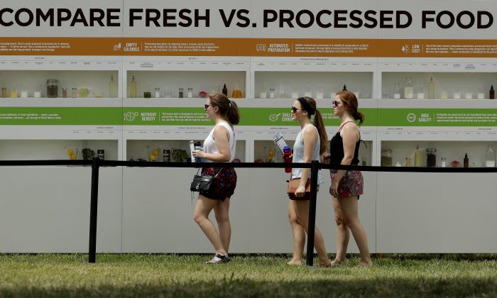 Khách hàng được nhìn thấy sự khác biệt trên các ô kệ khi xem một gian trưng bày sự tương phản giữ thực phẩm chế biến và thực phẩm tươi tại Lễ hội trồng trọt của Chipotle ở Thành phố Kansas, Missouri, vào ngày 23/07/2016. Lễ hội trồng trọt gói gọn xu hướng tiếp thị phổ biến nhất của ngành thực phẩm: vận động chống lại Big Food. (Ảnh: Charlie Riedel/AP)