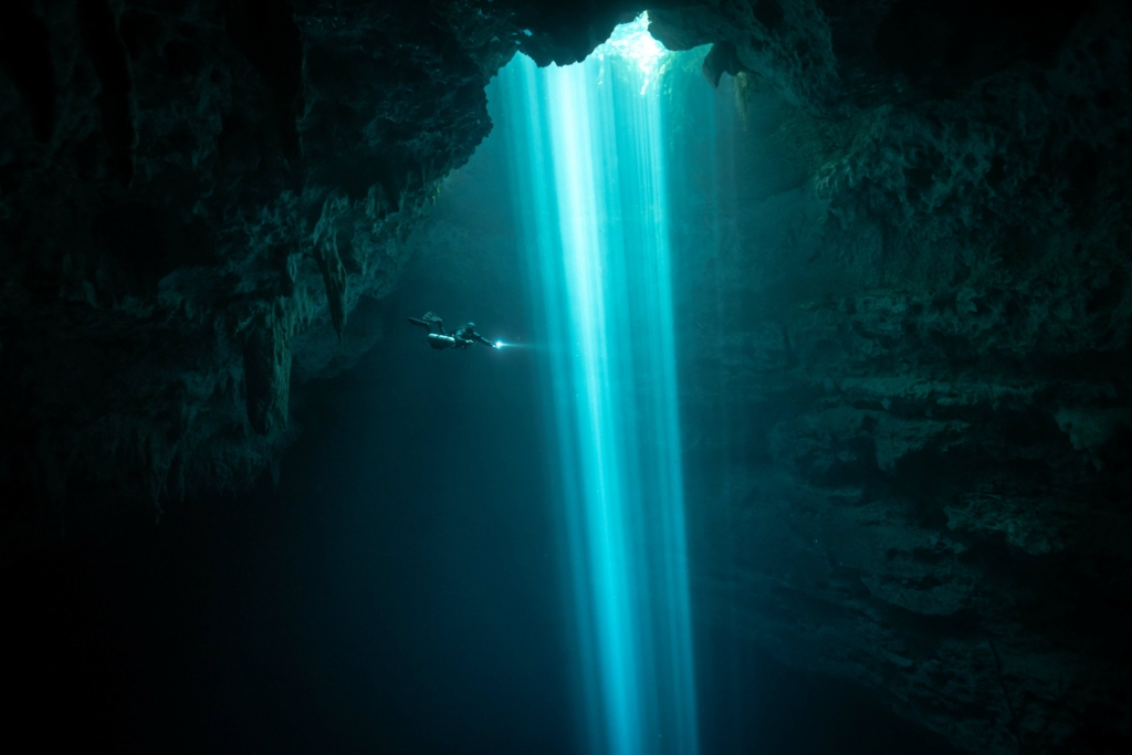 Một thợ lặn đi xuống vực sâu, với những chùm ánh sáng dẫn đường cho họ. (Ảnh: Đăng dưới sự cho phép của nhiếp ảnh gia Brandi Mueller)