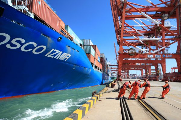 Các công nhân giúp một tàu container của Công ty Vận tải Biển Trung Quốc (COSCO) cập cảng tại một cảng ở Thanh Đảo, tỉnh Sơn Đông, Trung Quốc hôm 19/10/2018. (Ảnh: Reuters)