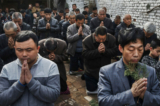 Các tín đồ Công giáo Trung Quốc quỳ gối và cầu nguyện trong buổi Thánh lễ Chúa Nhật Lễ Lá vào Tuần thánh Chúa Nhật Phục Sinh tại một nhà thờ “ngầm” hoặc “không chính thức” vào ngày 09/04/2017 gần Thạch Gia Trang, tỉnh Hà Bắc, Trung Quốc. Trung Quốc, một quốc gia theo thuyết vô thần, đặt ra một số hạn chế đối với các tín đồ Cơ Đốc, chỉ cho phép thực hành đức tin hợp pháp tại các nhà thờ được nhà nước chấp thuận. Chính sách này đã thúc đẩy ngày càng nhiều tín hữu Cơ Đốc và những người cải đạo theo Cơ Đốc Giáo ‘ngầm’ thành các giáo hội bí mật hoạt động tại nhà riêng và các địa điểm khác. (Ảnh: Kevin Frayer/Getty Images)