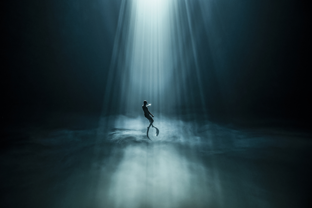 Một thợ lặn tự do lơ lửng giữa các chùm ánh sáng trong một hố sụt sâu. (Ảnh: Được sự cho phép của nhiếp ảnh gia Fabrice Guerin)