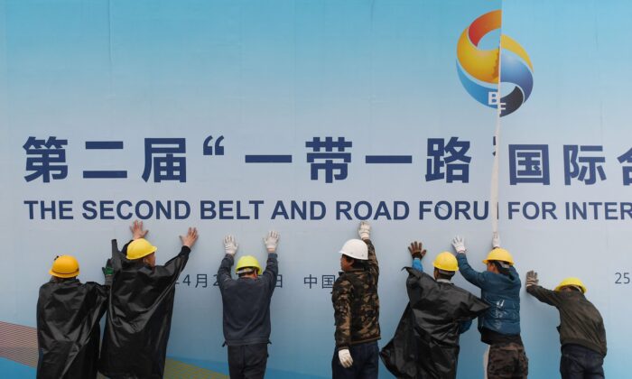 Công nhân tháo dỡ một bảng panel quảng cáo Diễn đàn Vành đai và Con đường bên ngoài địa điểm diễn ra diễn đàn này ở Bắc Kinh hôm 27/04/2019. (Ảnh: Greg Baker/AFP/Getty Images)