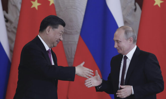 Tổng thống Nga Vladimir Putin và lãnh đạo Trung Quốc Tập Cận Bình bắt tay khi kết thúc họp báo chung sau cuộc hội đàm tại Điện Kremlin ở Moscow vào ngày 05/06/2019. (Ảnh: Maxim Shipenkov/AFP qua Getty Images)