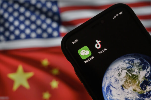 Trong bức ảnh minh họa này, có thể thấy một chiếc điện thoại di động hiển thị logo của hai ứng dụng WeChat và TikTok của Trung Quốc trước một màn hình hiển thị cờ của Hoa Kỳ và Trung Quốc trên một trang internet, vào ngày 22/09/2020, tại Bắc Kinh, Trung Quốc. (Ảnh: Kevin Frayer/Getty Images)