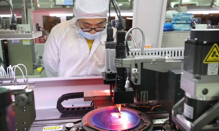 Một nhân viên quan sát quá trình sản xuất vi mạch bán dẫn tại một nhà máy ở Nam Thông, tỉnh Giang Tô, miền đông Trung Quốc, vào ngày 17/03/2021. (Ảnh: STR/AFP qua Getty Images)