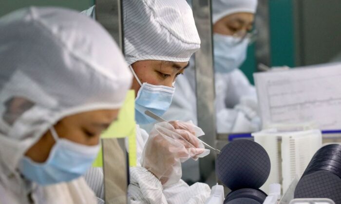 Công nhân sản xuất vi mạch bán dẫn tại một nhà máy của Công ty Bán dẫn Jiejie ở thành phố Nam Thông, phía đông tỉnh Giang Tô của Trung Quốc, hôm 17/03/2021. (Ảnh: STR/AFP qua Getty Images)