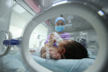 Một nhân viên y tế cho em bé bú tại một bệnh viện ở Đan Trại, tỉnh Quý Châu, tây nam Trung Quốc, vào ngày 11/05/2021. (Ảnh: STR/AFP qua Getty Images)