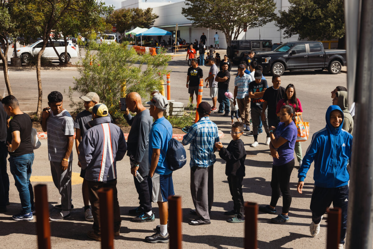 Các nhóm người nhập cư bất hợp pháp tìm kiếm tị nạn chờ đợi bên ngoài Trung tâm Nguồn lực cho Người nhập cư để nhận thức ăn từ Tổ chức Từ thiện Công giáo San Antonio ở San Antonio, Texas, vào ngày 19/09/2022. (Ảnh: Jordan Vonderhaar/Getty Images)