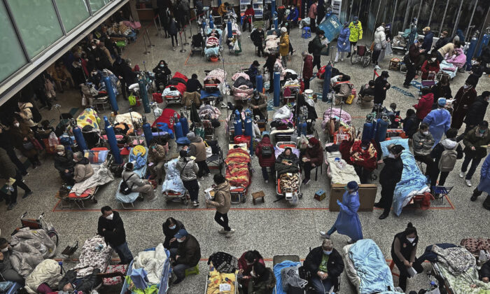Các bệnh nhân được người thân và nhân viên y tế chăm sóc khi họ nằm trên những chiếc giường được bố trí ở khu vực giếng trời của một bệnh viện đông đúc ở Thượng Hải, Trung Quốc, hôm 13/01/2023. (Ảnh: Kevin Frayer/Getty Images)