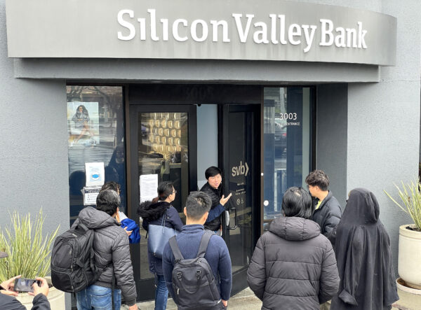 Một nhân viên (giữa) nói với mọi người rằng trụ sở chính của Silicon Valley Bank (SVB) đã đóng cửa ở Santa Clara, California, hôm 10/03/2023. (Ảnh: Justin Sullivan/Getty Images)