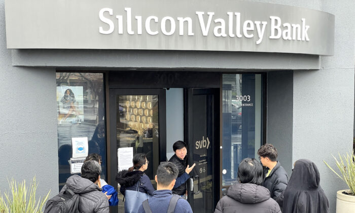 Một công nhân (giữa) nói với mọi người rằng trụ sở chính của Silicon Valley Bank(SVB) đã đóng cửa ở Santa Clara, tiểu bang California, hôm 10/03/2023. (Ảnh: Justin Sullivan/Getty Images)
