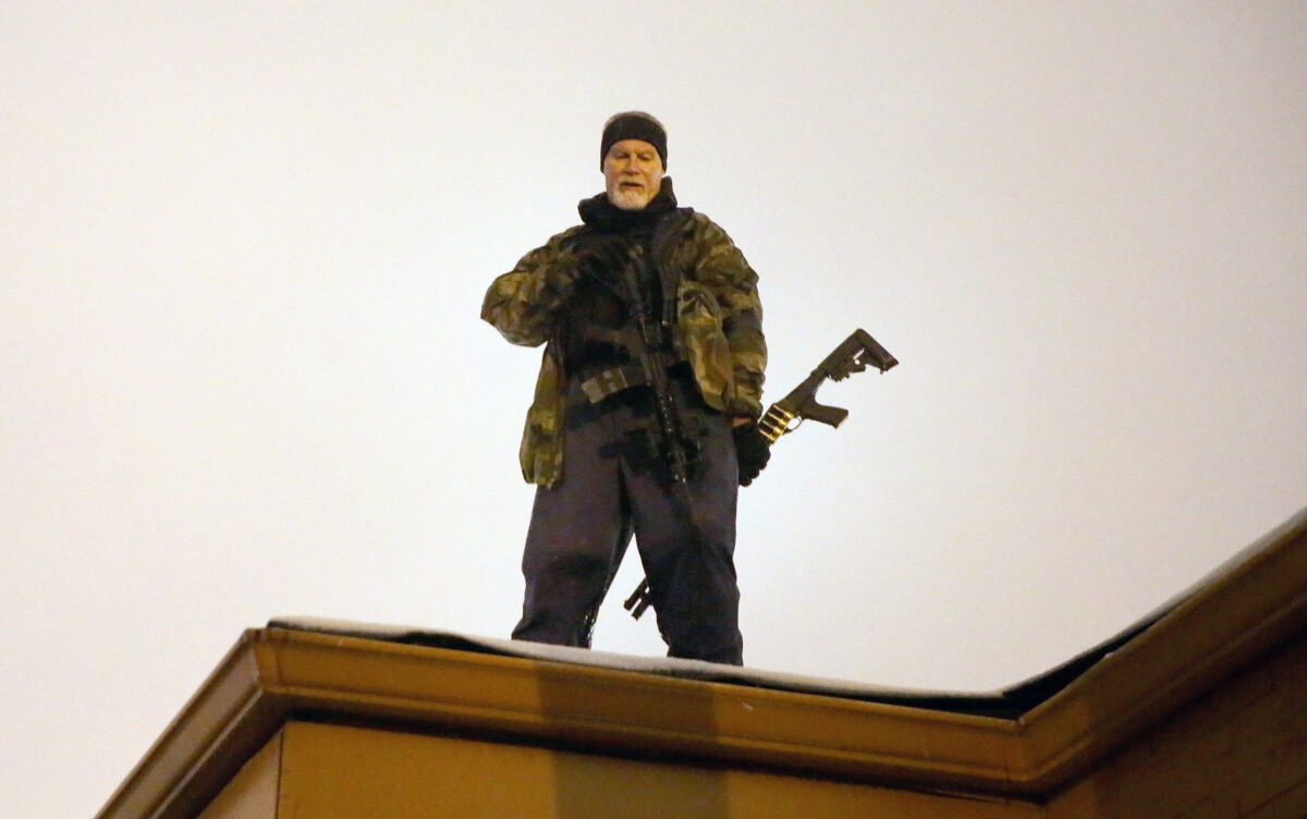 Ông John Karriman, một tình nguyện viên của Oath Keepers, đứng bảo vệ trên sân thượng của một doanh nghiệp vào ngày 26/11/2014, tại Ferguson, Missouri. (Ảnh: Scott Olson/Getty Images)
