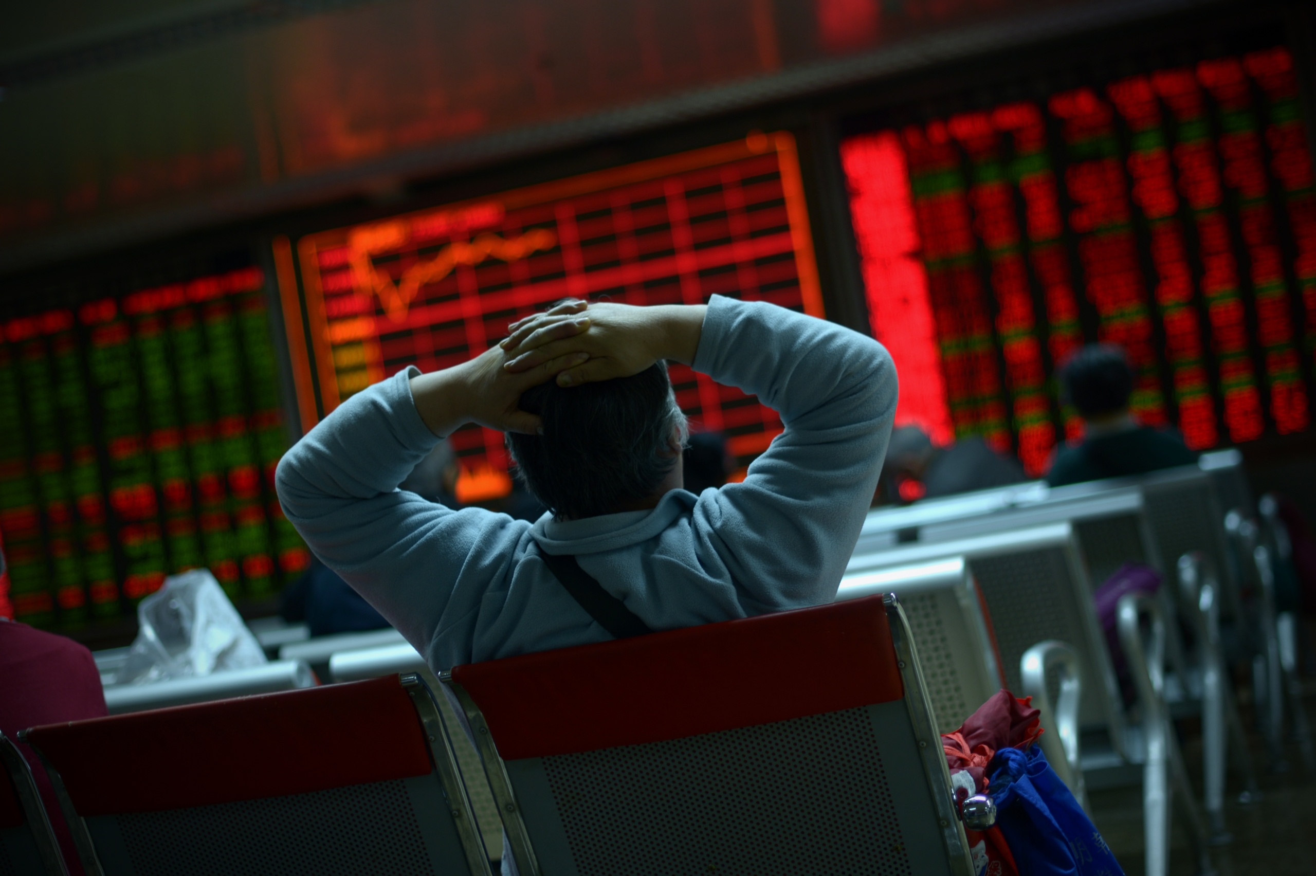 Một nhà đầu tư nhìn vào màn hình hiển thị diễn biến thị trường chứng khoán tại một công ty chứng khoán ở Bắc Kinh hôm 08/01/2016. (Ảnh: Wang Zhao/AFP qua Getty Images)