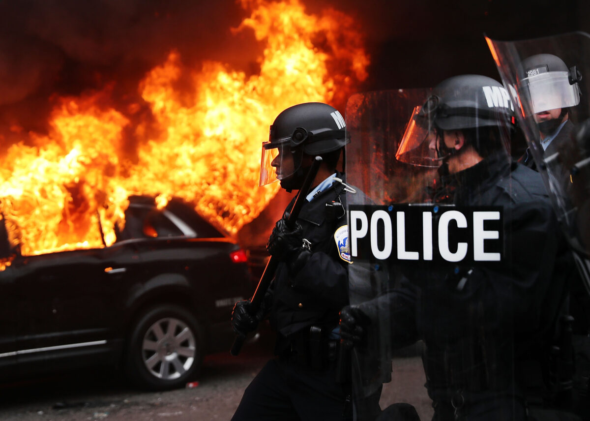 Cảnh sát và những kẻ bạo loạn đụng độ ở trung tâm thành phố của Hoa Thịnh Đốn sau khi một chiếc xe limo bị phóng hỏa sau lễ nhậm chức của Tổng thống Donald Trump vào ngày 20/01/2017. (Ảnh: Spencer Platt/Getty Images)