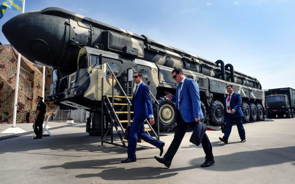 Các chuyên gia quân sự đi ngang qua một hỏa tiễn đạn đạo liên lục địa (ICBM) Topol của Nga tại khu vực triển lãm ở Công viên Ái quốc Kubinka bên ngoài Moscow vào ngày 22/08/2017. (Ảnh: Alexander Nemenov/AFP/Getty Images)
