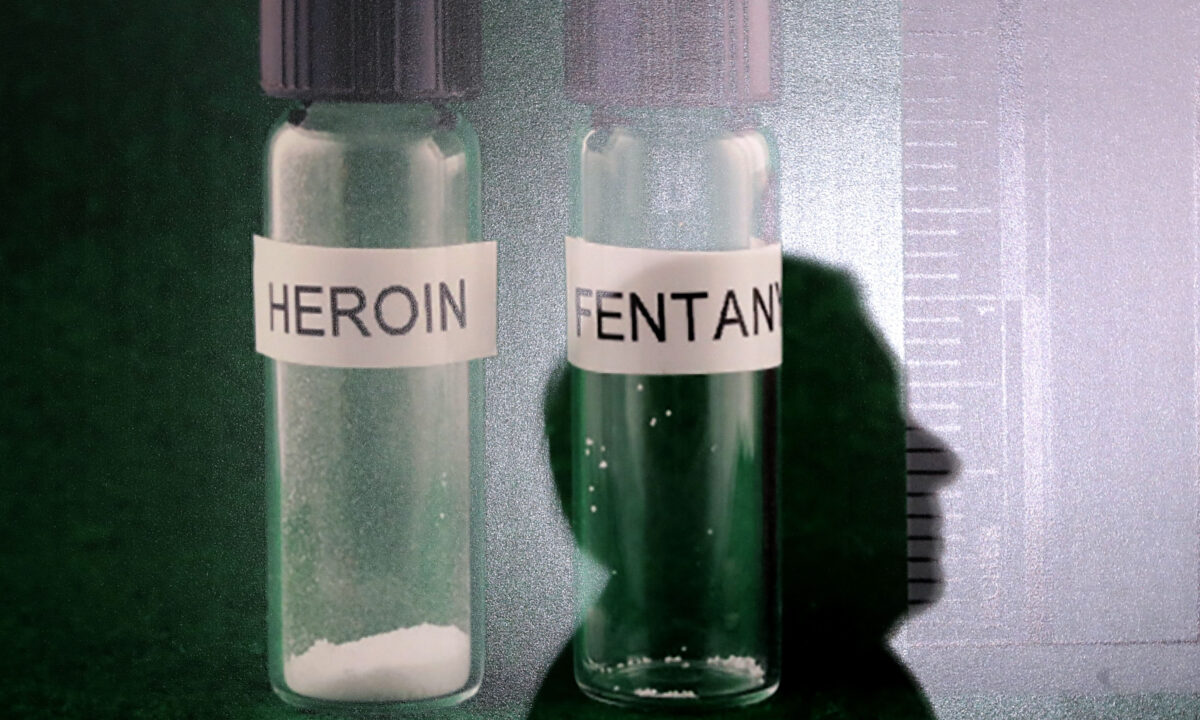 Bóng của một người đàn ông in trên bức ảnh chụp heroin và fentanyl trong một cuộc họp báo tại Capitol Hill ở Hoa Thịnh Đốn vào ngày 22/03/2018. (Ảnh: Chip Somodevilla/Getty Images)