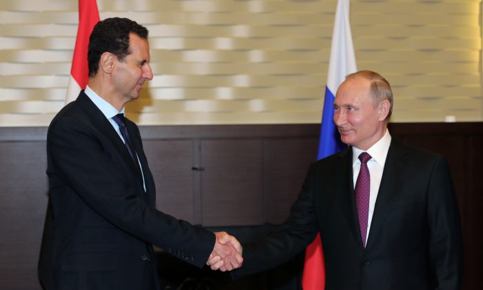 Tổng thống Nga Vladimir Putin (bên phải) bắt tay với người đồng cấp Syria Bashar al-Assad trong cuộc gặp của họ ở thành phố Sochi, Nga, vào ngày 17/05/2018. (Ảnh: Mikhail Klimentyev/AFP/Getty Images)