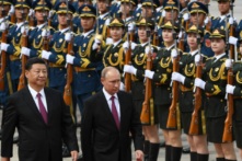 Tổng thống Nga Vladimir Putin (giữa) duyệt một đội quân danh dự với nhà lãnh đạo Trung Quốc Tập Cận Bình (trái) trong một buổi lễ tiếp đón bên ngoài Đại lễ đường Nhân dân ở Bắc Kinh vào ngày 08/06/2018. (Ảnh: Greg Baker/POOL/AFP qua Getty Images)