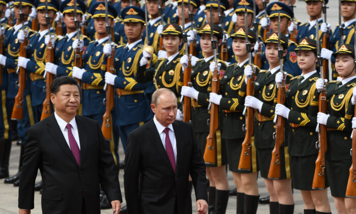 Tổng thống Nga Vladimir Putin (giữa) duyệt một đội quân danh dự với nhà lãnh đạo Trung Quốc Tập Cận Bình (trái) trong một buổi lễ tiếp đón bên ngoài Đại lễ đường Nhân dân ở Bắc Kinh vào ngày 08/06/2018. (Ảnh: Greg Baker/POOL/AFP qua Getty Images)