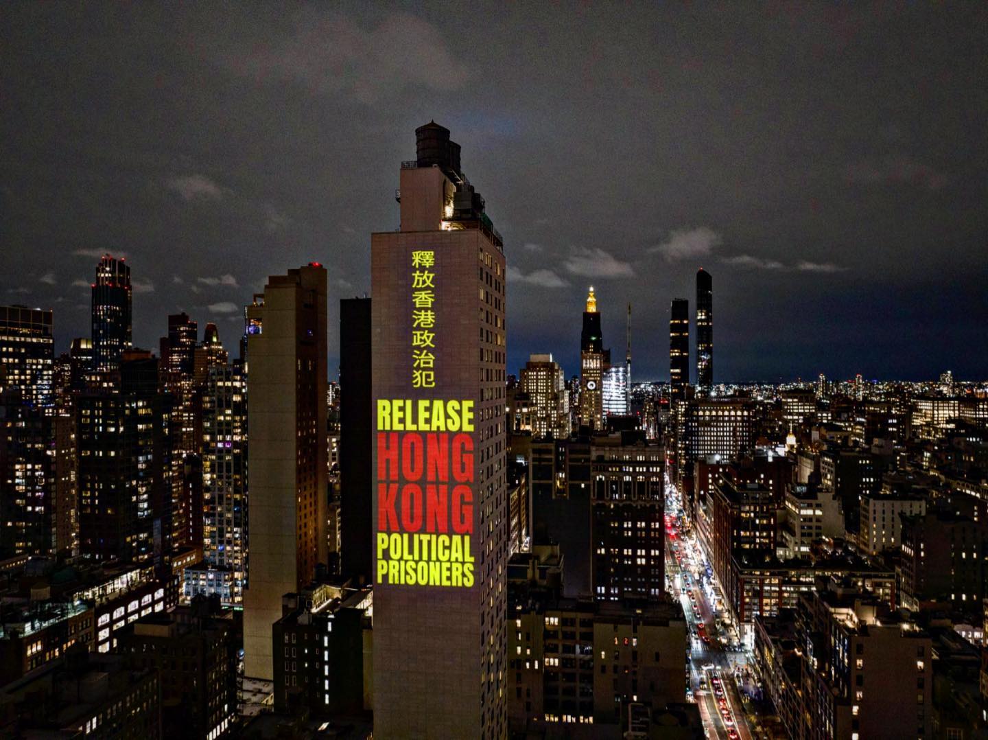 Màn trình chiếu quy mô lớn ở Manhattan, New York, hiển thị một thông điệp: ‘Trả tự do cho các tù nhân chính trị Hồng Kông’ bằng tiếng Trung và tiếng Anh, vào đêm trước ngày 08/03/2023. (Ảnh: Đăng dưới sự cho phép của Tổ chức Ủy ban vì Tự do ở Hồng Kông)