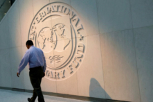 Một người đàn ông đi ngang qua logo của Quỹ Tiền tệ Quốc tế (IMF) tại trụ sở chính của tổ chức này ở Hoa Thịnh Đốn vào ngày 10/05/2018. (Ảnh: Yuri Gripas/File Photo/Reuters)