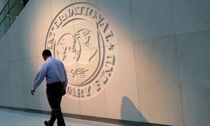 Một người đàn ông đi ngang qua logo của Quỹ Tiền tệ Quốc tế (IMF) tại trụ sở chính của tổ chức này ở Hoa Thịnh Đốn vào ngày 10/05/2018. (Ảnh: Yuri Gripas/File Photo/Reuters)