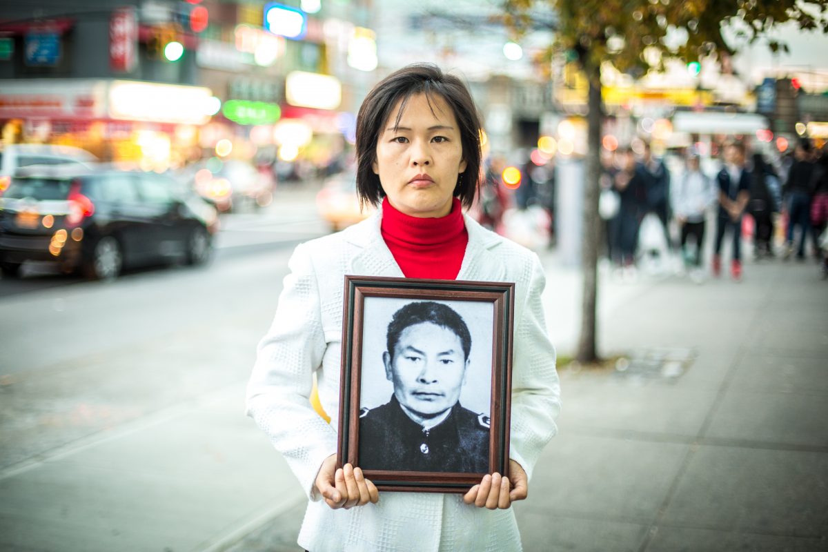 Cô Giang Lê (Jiang Li) ở Flushing, Queens, vào ngày 01/11/2015, cầm một bức ảnh của cha cô, người đã bị Đảng Cộng sản Trung Quốc sát hại ở Trung Quốc vì tu luyện Pháp Luân Công. (Ảnh: Benjamin Chasteen/Epoch Times)