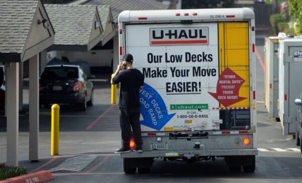 Một người đàn ông đang nói chuyện qua điện thoại di động khi đang đứng sau một chiếc xe tải đang di chuyển ở Pacifica, California, vào ngày 26/01/2016. (Ảnh: Josh Edelson/AFP qua Getty Images)
