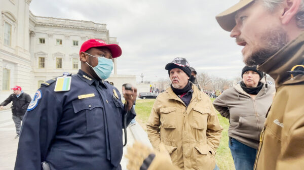 Trung úy Cảnh sát Điện Capitol Tarik Khalid Johnson đề nghị các thành viên của tổ chức Oath Keepers, ông Steve (giữa) và ông Michael Nichols giúp giải cứu các sĩ quan cảnh sát bị mắc kẹt bên trong Điện Capitol ngày 06/01/2021. (Ảnh: Rico La Starza/Đặc quyền của The Epoch Times)