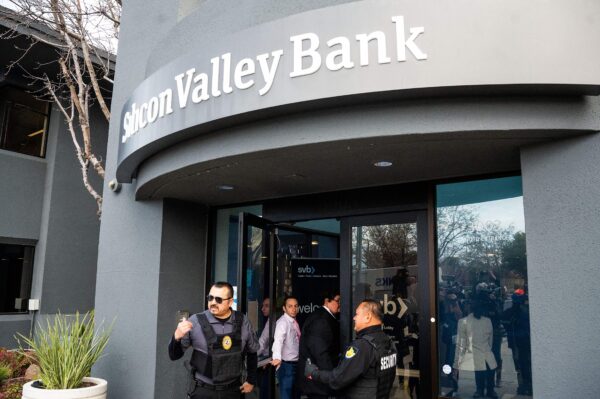 Nhân viên bảo vệ và đại diện FDIC mở cửa một chi nhánh Silicon Valley Bank (SVB) cho khách hàng tại trụ sở của SVB ở Santa Clara, California, hôm 13/03/2023. (Ảnh : Noah Berger/AFP/Getty Images)