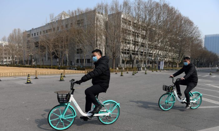 Hai nam sinh đạp xe trong khu đất trống của Đại học Thanh Hoa ở Bắc Kinh vào ngày 28/02/2020. (Ảnh: Greg Baker/AFP qua Getty Images)
