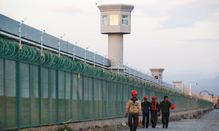 Công nhân đi bộ bên hàng rào vành đai của nơi chính thức được biết đến là một trung tâm giáo dục kỹ năng nghề nghiệp ở Đạt Phản Thành (Dabancheng) thuộc Khu tự trị Duy Ngô Nhĩ Tân Cương, Trung Quốc, vào ngày 04/09/2018. (Ảnh: Thomas Peter/Reuters/Ảnh Tư liệu)