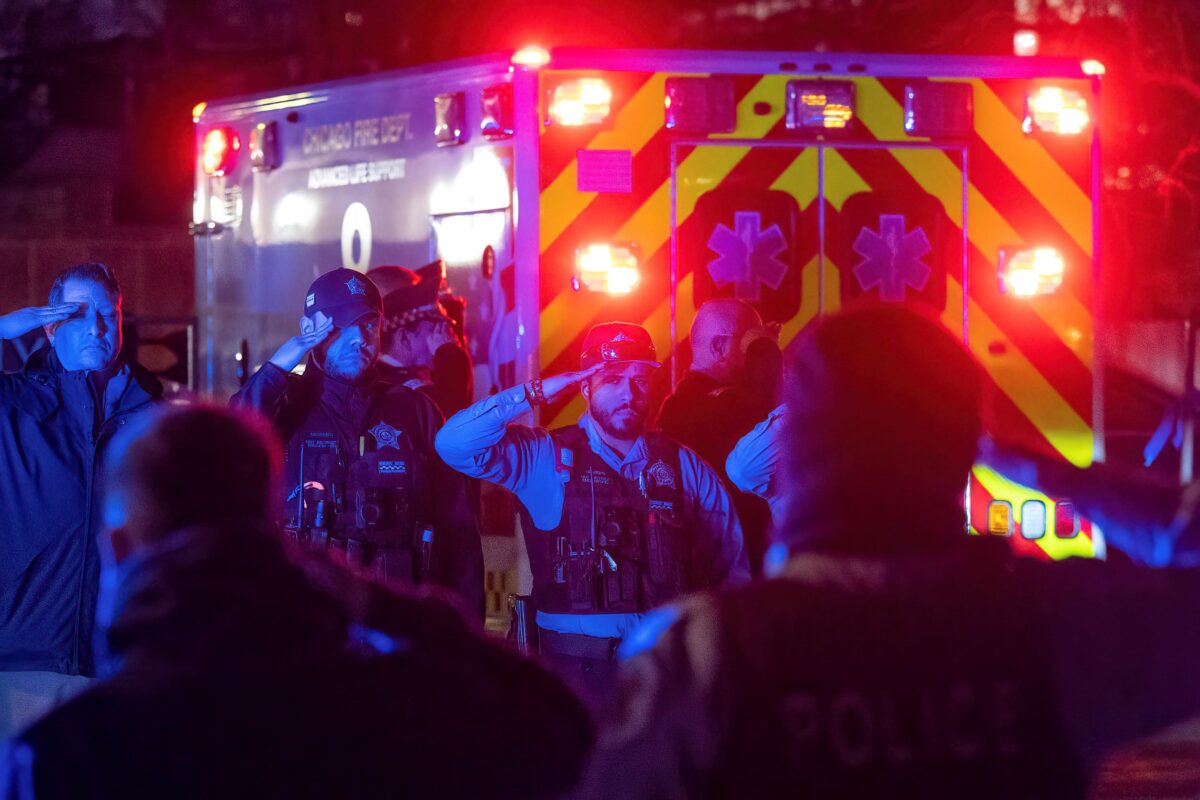 Các sĩ quan cảnh sát và lính cứu hỏa Chicago chào xe chở thi hài của một sĩ quan cảnh sát Chicago bị bắn thiệt mạng khi phương tiện này đến Văn phòng Giám định Y tế Quận Cook, hôm 01/03/2023. (Ảnh: Tyler Pasciak LaRiviere/Sun-Times/Chicago Sun- qua AP)