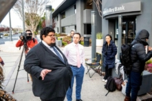 Đại diện của FDIC, ông Luis Mayorga (trái) và ông Igor Fayermark bảo đảm với các khách hàng của Silicon Valley Bank rằng tiền của họ có sẵn trước khi chi nhánh tại trụ sở của SVB ở Santa Clara, California, mở cửa hôm 13/03/2023. (Ảnh: Noah Berger/AFP qua Getty Images)