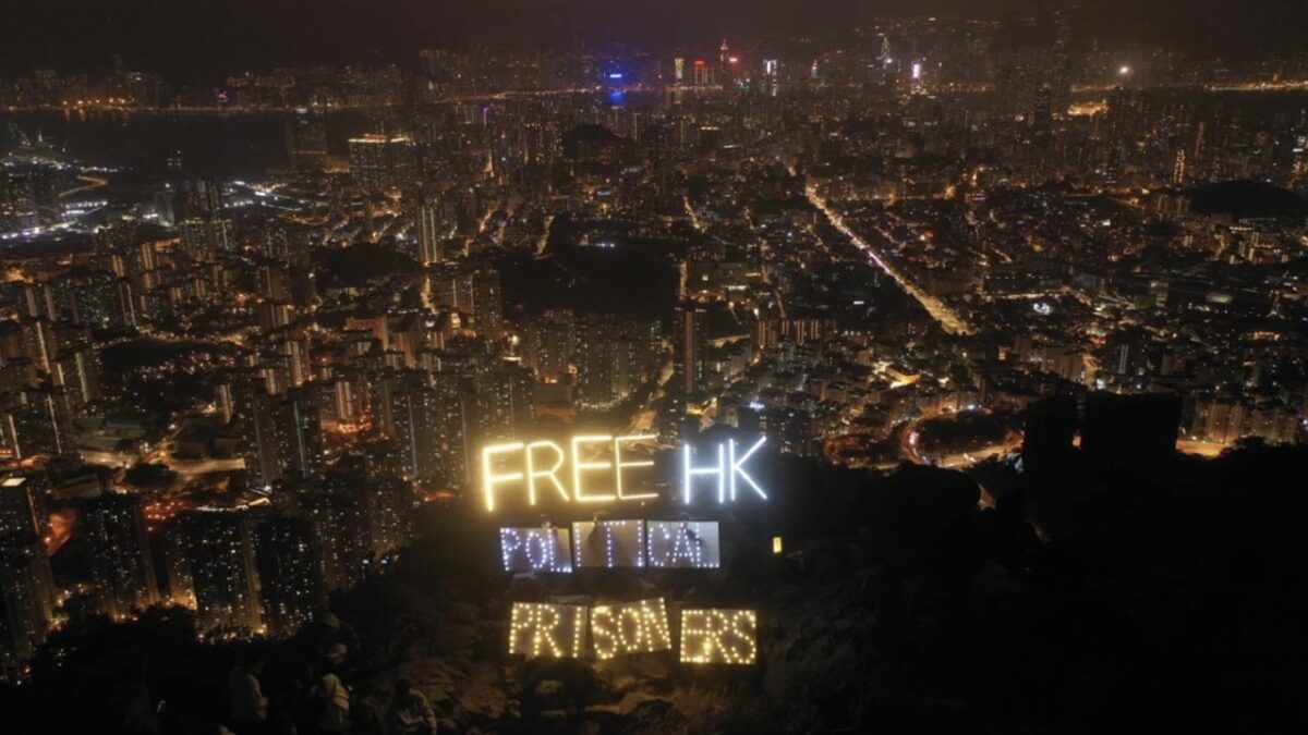 Hơn một chục người Hồng Kông đang cầm đèn LED và nến điện tử hiển thị dòng chữ “Trả tự do cho các tù nhân chính trị Hồng Kông” (Free HK political prisoners) trên đỉnh Núi Sư tử ở Hồng Kông, hôm 31/12/2022. (Ảnh: Hui Tat/The Epoch Times)