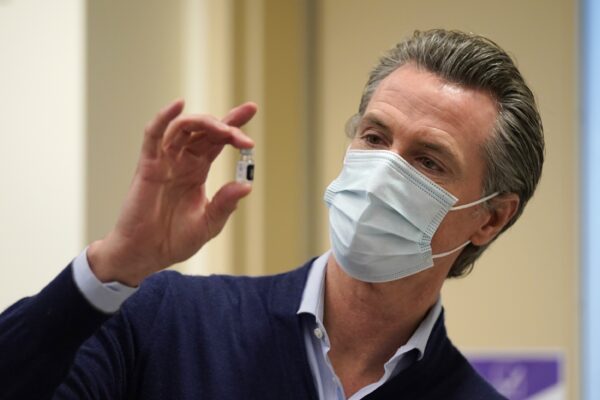 Thống đốc California Gavin Newsom cầm một lọ vaccine COVID-19 mới tại Bệnh viện Kaiser Permanente Los Angeles ở Los Angeles, California, vào ngày 14/12/2020. (Ảnh: Jae C. Hong/Pool/Getty Images)
