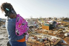 Bà Wonder Bolden bế cháu gái nhỏ 1 tuổi Journey Bolden của mình khi bà xem xét phần còn lại của ngôi nhà di động bị lốc xoáy phá hủy của mẹ bà ở Rolling Fork, Mississippi, hôm 25/03/2023. (Ảnh: Rogelio V. Solis/AP Photo)