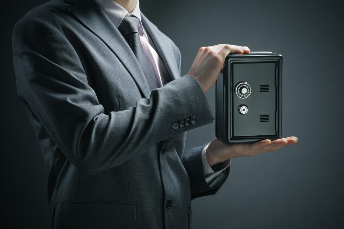 Doanh nhân bảo vệ tiền tiết kiệm của mình trong két sắt. (Ảnh: Shutterstock)