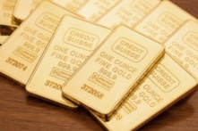 Thanh vàng một ounce trên bề mặt gỗ sẫm màu. (Ảnh: Ken Weinrich/Shutterstock)