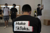 Một người đàn ông mặc một chiếc áo thun in dòng quảng cáo TikTok tại một cửa hàng Apple ở Bắc Kinh, Trung Quốc, vào ngày 17/07/2020. (Ảnh: Ng Han Guan/AP Photo)