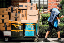 Một nhân viên giao hàng của Amazon kéo một xe hàng chở đầy các gói hàng ở Thành phố New York vào ngày 21/06/2021. (Ảnh: Brendan McDermid/Reuters)