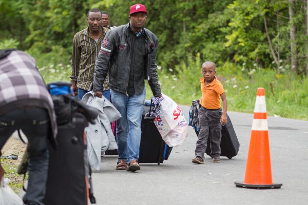 Những người xin tị nạn đến biên giới Canada/Mỹ gần Champlain, New York, vào ngày 06/08/2017. Những ngày vừa qua, số người vượt biên trái phép lên đến hàng trăm người. (Ảnh: Geoff Robins/AFP/Getty Images)
