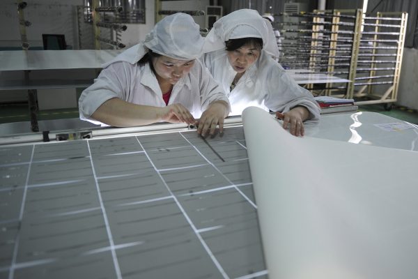 Công nhân lắp ráp các tấm pin mặt trời tại một nhà máy ở Hợp Phì, tỉnh An Huy, Trung Quốc, vào ngày 27/07/2013. (Ảnh: AP Photo)