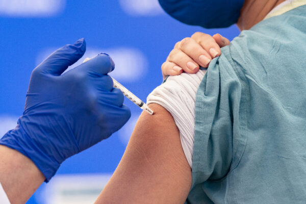 Một y tá được chích ngừa một liều vaccine COVID-19 tại Orange, California, hôm 16/12/2020. (Ảnh: John Fredricks/The Epoch Times)