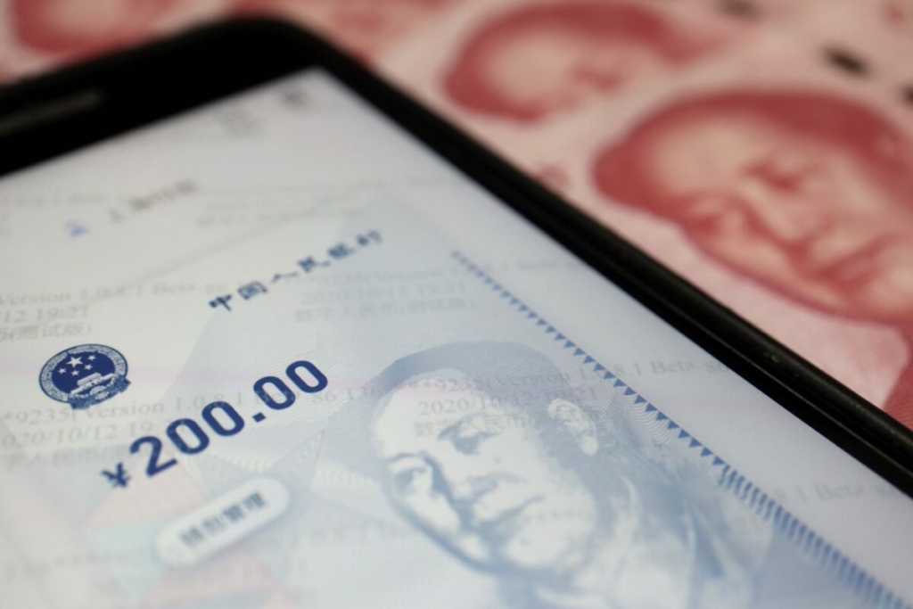 Ứng dụng chính thức cho đồng nhân dân tệ điện toán của Trung Quốc trên điện thoại di động bên cạnh tờ bạc 100 nhân dân tệ vào ngày 16/10/2020. (Ảnh: Florence Lo/Illustration/Reuters