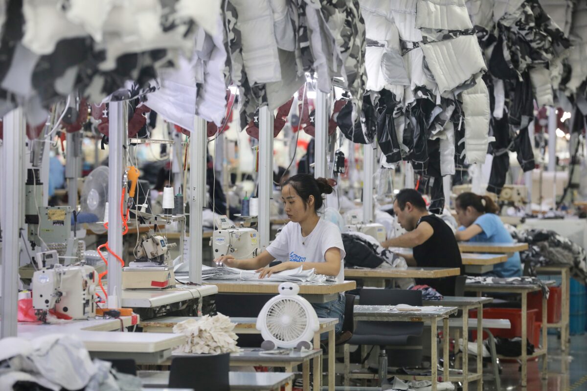Công nhân đang may áo khoác tại một nhà máy cho công ty may mặc Trung Quốc Bosideng ở Nam Thông, tỉnh Giang Tô, Trung Quốc, vào ngày 24/09/2019. (Ảnh: STR/AFP/Getty Images)
