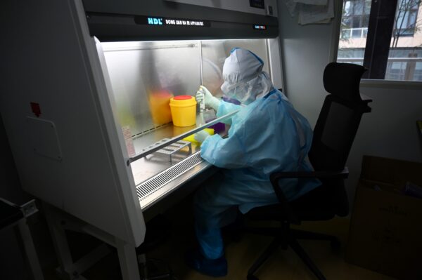 Một kỹ thuật viên xử lý các mẫu bệnh phẩm trong một phòng thí nghiệm tại công ty công nghệ sinh học Trung Quốc Coyote trước khi xét nghiệm các mẫu này trong Flash 20, một mô hình máy được phát triển để xét nghiệm nhanh COVID-19 ở Bắc Kinh, vào ngày 27/09/2020. (Ảnh: Greg Baker/AFP qua Getty Images)