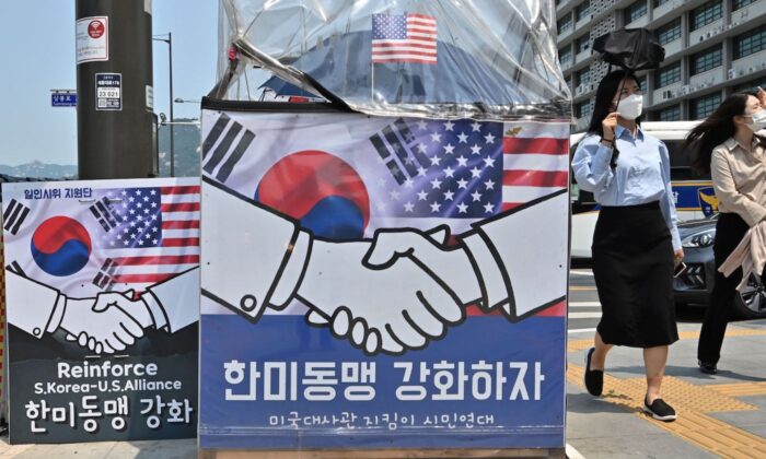 Người đi bộ đi ngang qua các biểu ngữ gần đại sứ quán Hoa Kỳ ở Seoul, Nam Hàn, vào ngày 20/05/2022. (Ảnh: Jung Yeon-je/AFP qua Getty Images)